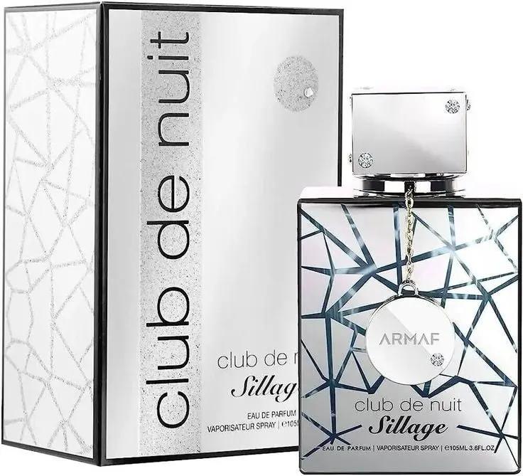 A bottle of Armaf Club de Nuit SILLAGE by Royal Oud Perfumes stands beside its matching white and silver geometric box. The clear bottle, with silver accents and a square cap, gives a fresh, modern vibe.