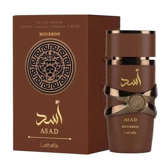 A brown and gold bottle of Lattafa ASAD BOURBON by Royal Oud Perfumes sits beside its lion head–adorned box with Arabic script. This especiado-amaderado fragrance features metallic accents and a modern design.