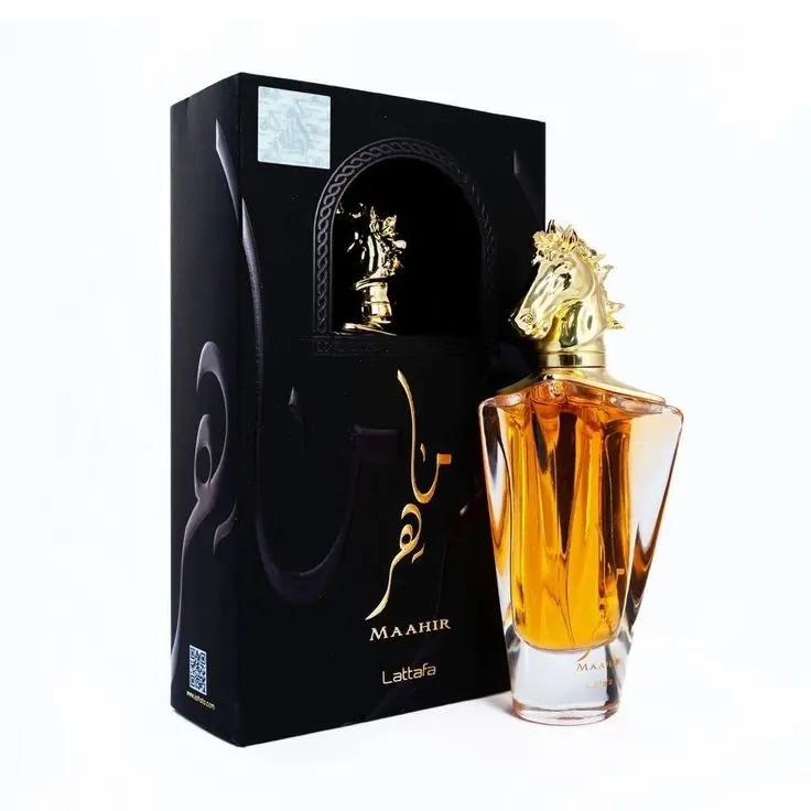 A bottle of Lattafa MAHIR by Royal Oud Perfumes, featuring amber liquid and a gold horse head cap, is shown beside its black box with gold Arabic and English text, reflecting the perfume’s floral and fruity essence.