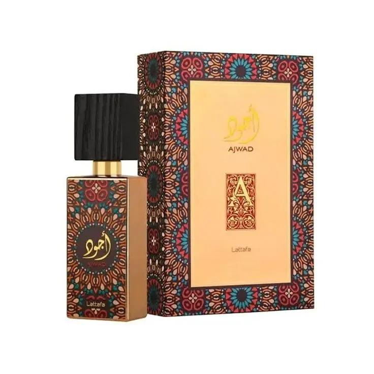 A bottle of Lattafa AJWAD by Royal Oud Perfumes, with a black cap, is placed next to its ornate, multicolored box with gold Arabic script—a sophisticated unisex Arabic fragrance.