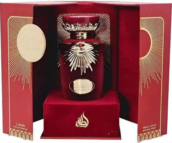 A luxurious red and gold Lattafa SAKEENA bottle by Royal Oud Perfumes sits in a decorative box with radiant sunburst designs, elegant gold accents, Arabic text, and “Eau de Parfum” on the side.