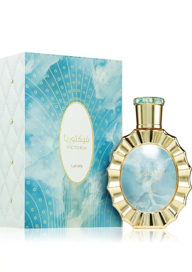 A bottle of Lataffa VICTORIA by Royal Oud Perfumes, featuring a gold, scalloped edge and a blue, cloud-patterned center, is shown beside its matching blue and gold box with Arabic and English text.